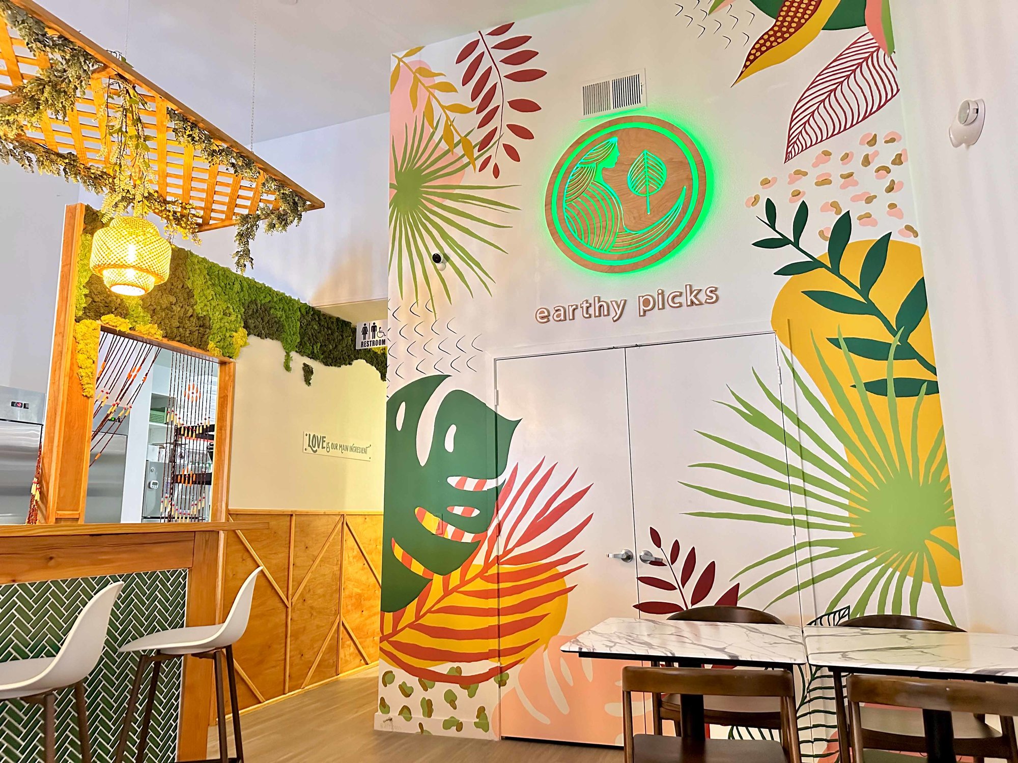 earthy picks mural on a white wall with greenery and warm colors